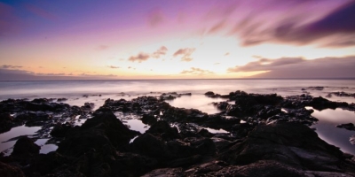 purple sunset over the water with tidepools